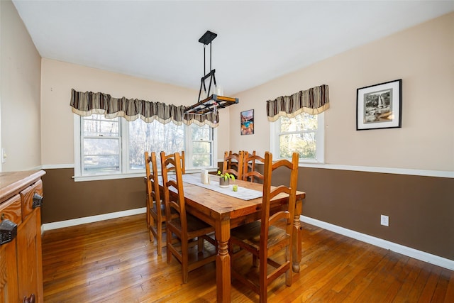 dining space featuring hardwood / wood-style flooring and baseboards