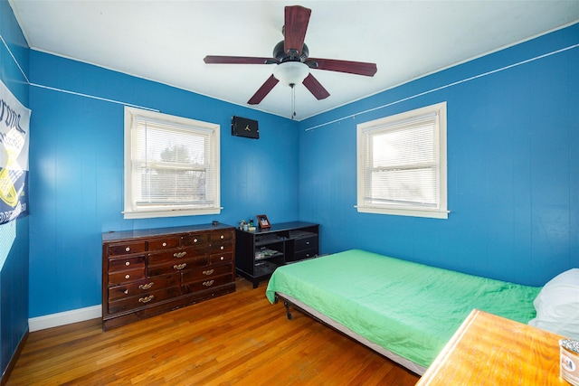 bedroom featuring multiple windows, wood finished floors, and ceiling fan