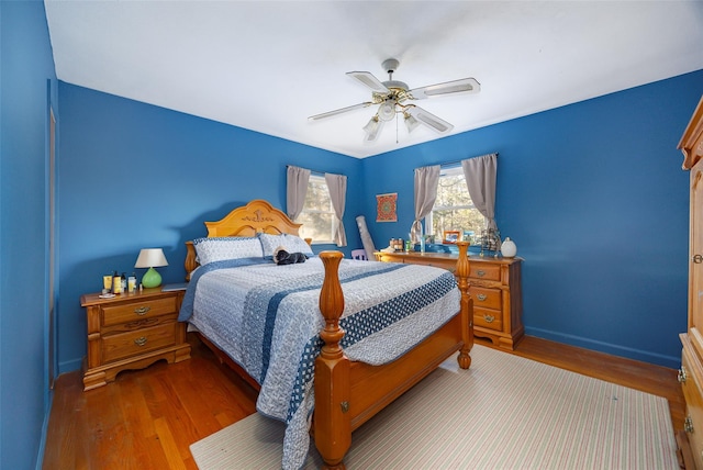 bedroom with baseboards, a ceiling fan, and wood finished floors