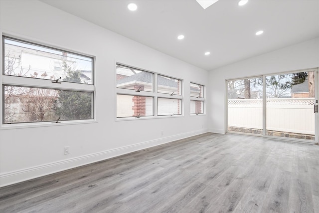 unfurnished room featuring lofted ceiling, baseboards, wood finished floors, and recessed lighting