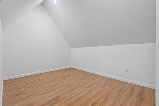 bonus room featuring vaulted ceiling, wood finished floors, and baseboards