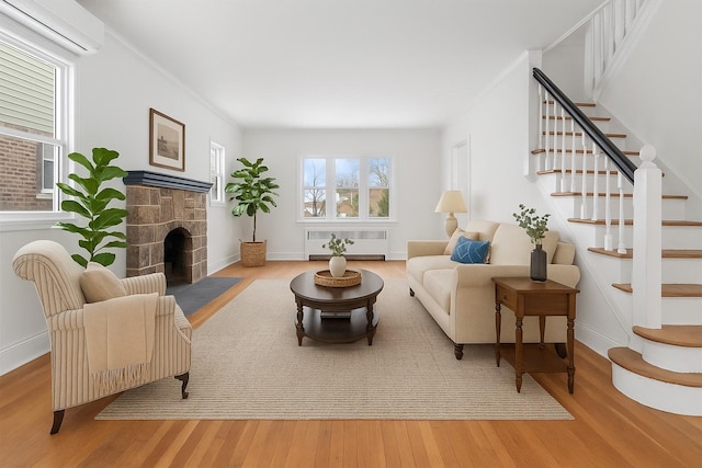 53-31 212th St, Bayside, NY 11364 - living room featuring a wall unit AC, radiator, wood finished floors, a fireplace, and ornamental molding