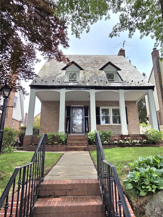53-31 212th St, Bayside, NY 11364 - view of front of home featuring covered porch, brick siding, a front lawn, and stairs