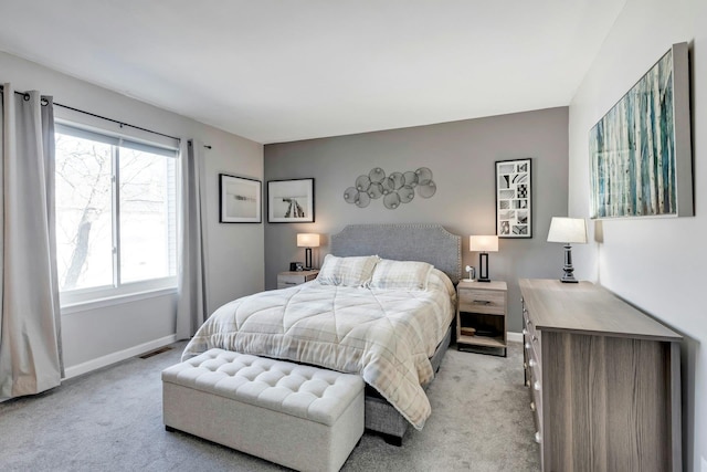 bedroom with baseboards, visible vents, and light colored carpet