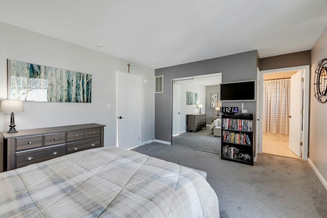 carpeted bedroom featuring baseboards, visible vents, a closet, and ensuite bathroom