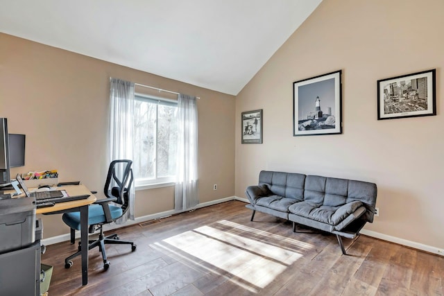 home office with visible vents, baseboards, vaulted ceiling, and wood finished floors