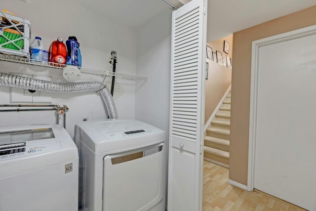 washroom with light wood finished floors, laundry area, and separate washer and dryer