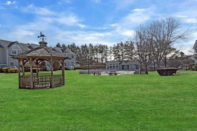 view of property's community featuring a patio area, a lawn, and a gazebo