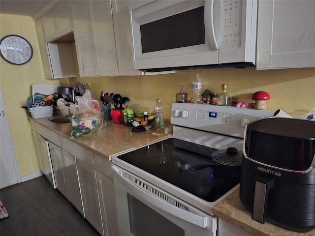 kitchen with light countertops, white appliances, and dark wood-style flooring