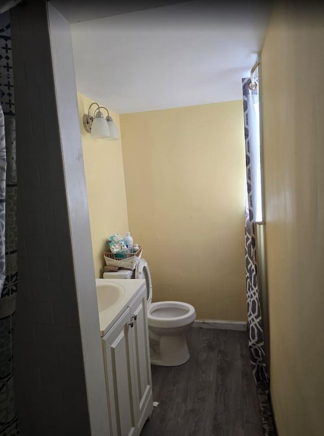 full bathroom featuring toilet, a shower with shower curtain, wood finished floors, vanity, and baseboards