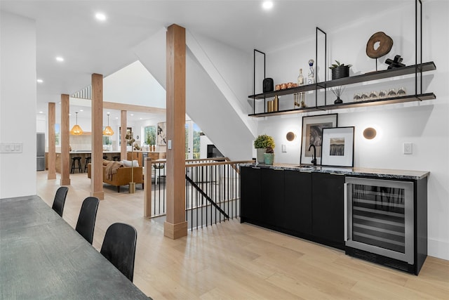 bar with wine cooler, recessed lighting, a sink, light wood-type flooring, and indoor wet bar