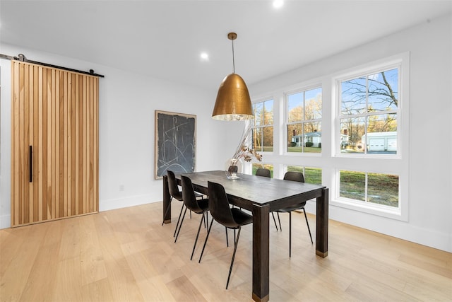 dining room with light wood-style floors, recessed lighting, baseboards, and a barn door