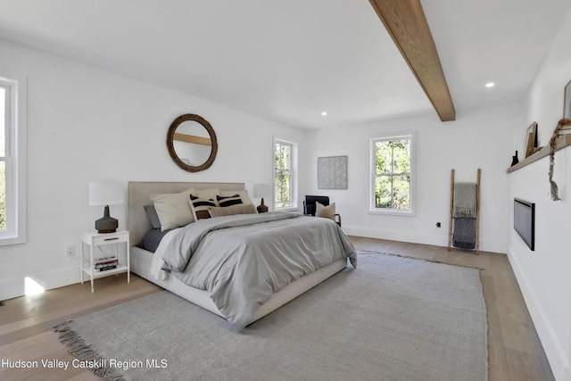 bedroom featuring wood finished floors, beam ceiling, and recessed lighting