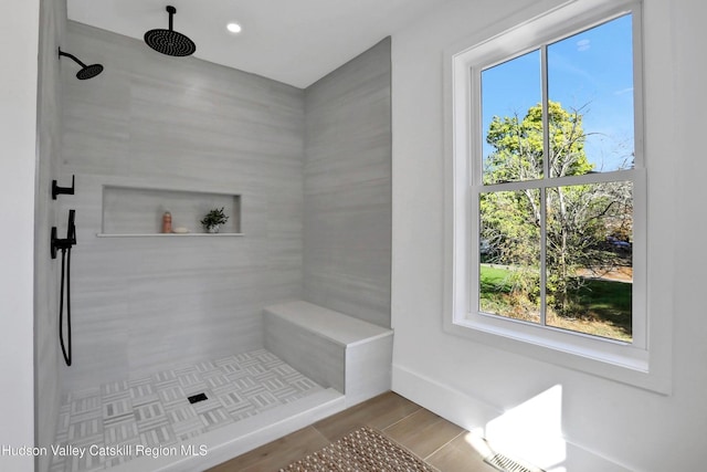 bathroom featuring plenty of natural light, wood finished floors, tiled shower, and recessed lighting