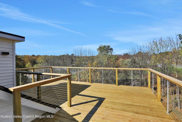 wooden terrace featuring a forest view