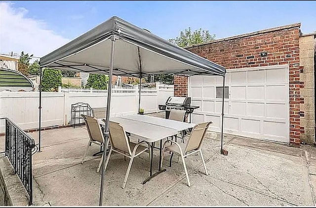 view of patio featuring outdoor dining area, fence, and a grill