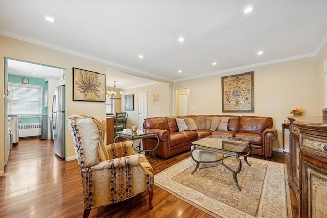 living area featuring crown molding, radiator heating unit, wood finished floors, and recessed lighting