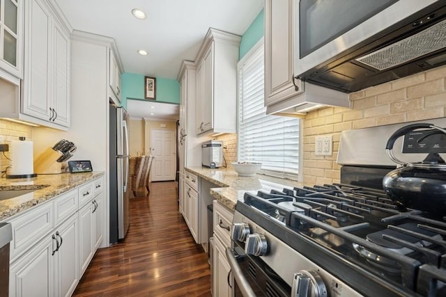 kitchen featuring light stone counters, recessed lighting, white cabinetry, appliances with stainless steel finishes, and dark wood-style floors