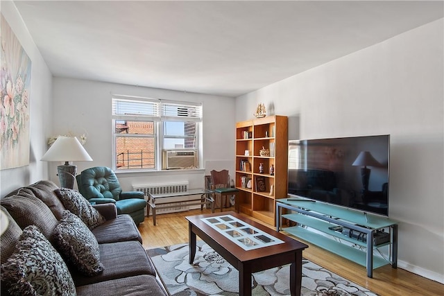 living area featuring cooling unit and wood finished floors