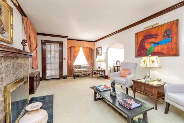 living area featuring light carpet, arched walkways, a stone fireplace, and crown molding