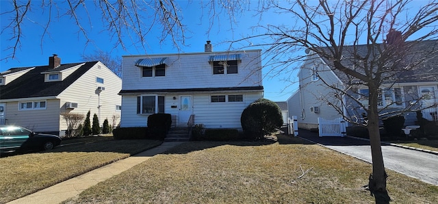 view of front of house with a front lawn and a chimney