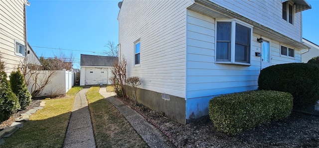 view of side of home with fence and an outdoor structure