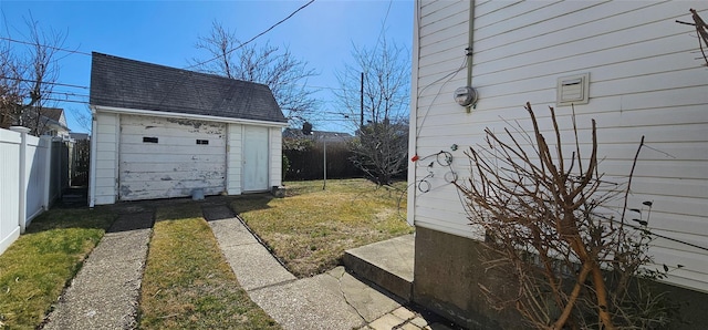 view of yard featuring a shed, an outdoor structure, a fenced backyard, and a detached garage