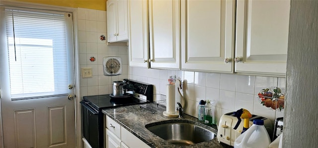 kitchen with electric range, visible vents, white cabinets, decorative backsplash, and dark stone countertops