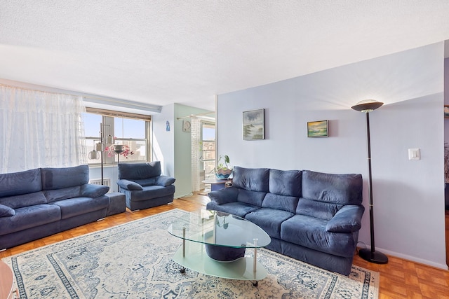 living area with a textured ceiling and baseboards