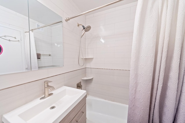 bathroom featuring tile walls, decorative backsplash, vanity, and shower / tub combo with curtain