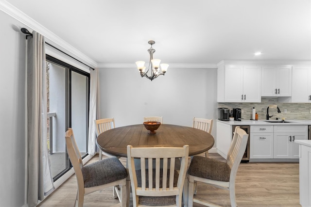 dining room featuring a chandelier, ornamental molding, and light wood finished floors