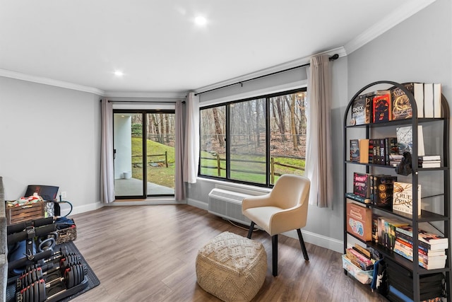 living area with wood finished floors, baseboards, and ornamental molding
