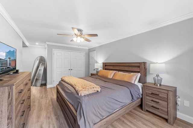 bedroom featuring baseboards, ornamental molding, a closet, and light wood-style flooring