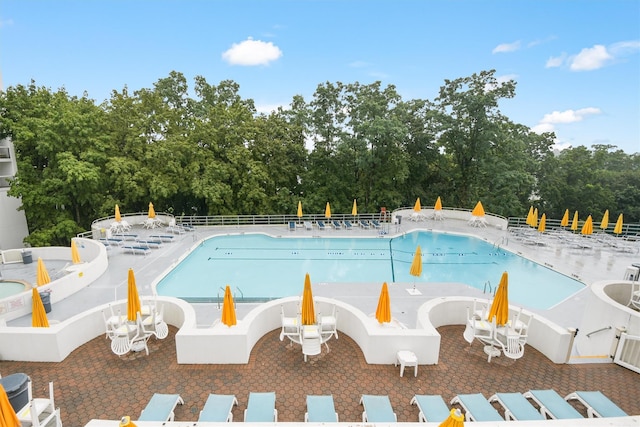 pool with a patio and fence