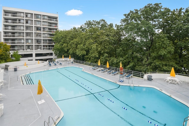 pool with a patio and fence