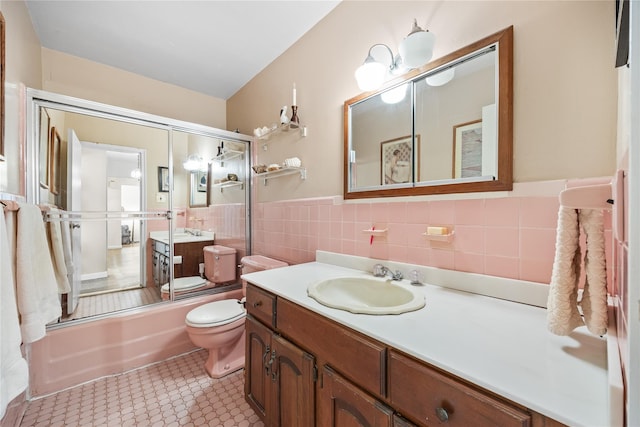 full bathroom featuring a wainscoted wall, shower / washtub combination, toilet, vanity, and tile walls