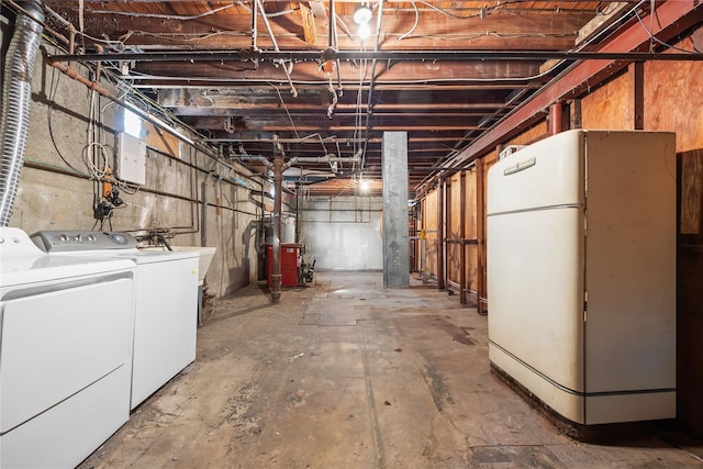 unfinished basement with washing machine and dryer and freestanding refrigerator