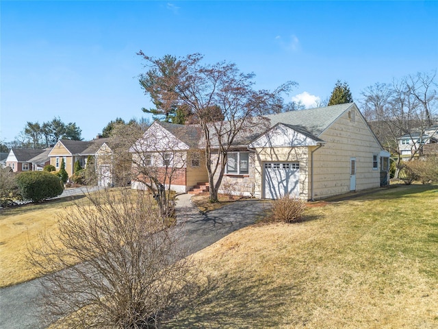 view of front of house featuring a front lawn, a garage, and driveway