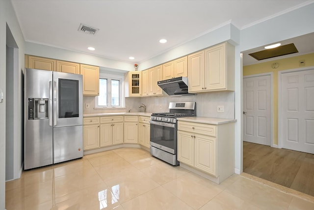 kitchen with light tile patterned floors, under cabinet range hood, stainless steel appliances, visible vents, and light countertops