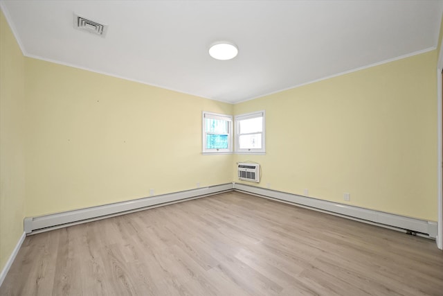 spare room featuring visible vents, wood finished floors, crown molding, a baseboard heating unit, and a wall mounted AC