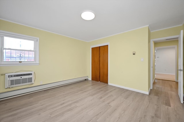 unfurnished room with a baseboard radiator, a wall unit AC, baseboards, ornamental molding, and light wood finished floors