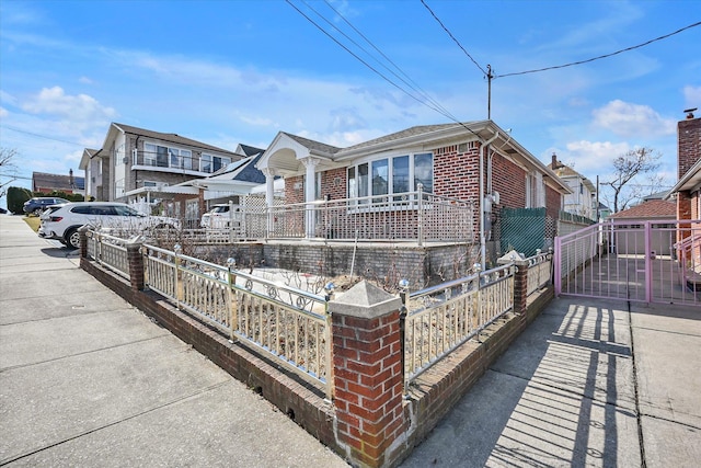 view of front of house featuring fence and brick siding