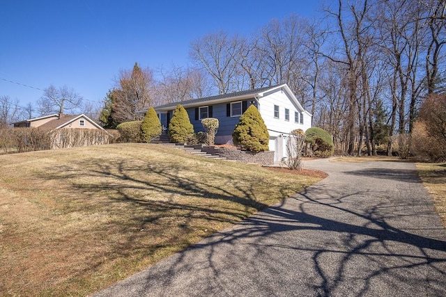 view of front of house with driveway, an attached garage, a front lawn, and fence