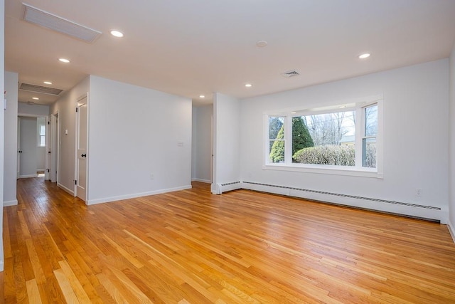 empty room with light wood-type flooring, visible vents, and a baseboard radiator