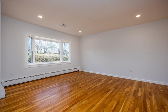 spare room with visible vents, a baseboard heating unit, recessed lighting, light wood finished floors, and baseboards