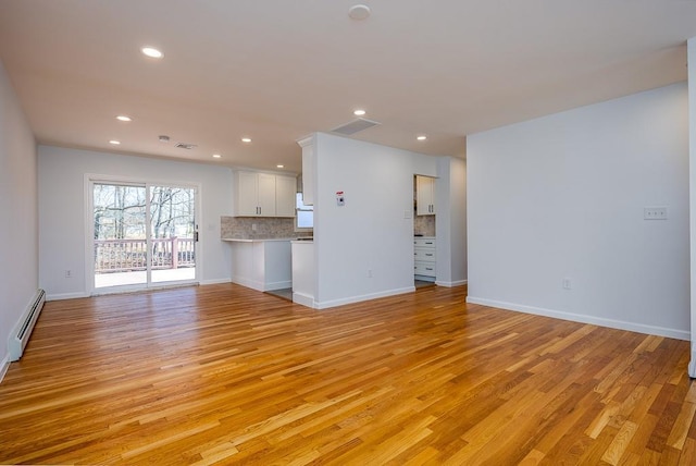 unfurnished living room with recessed lighting, a baseboard radiator, visible vents, and light wood finished floors