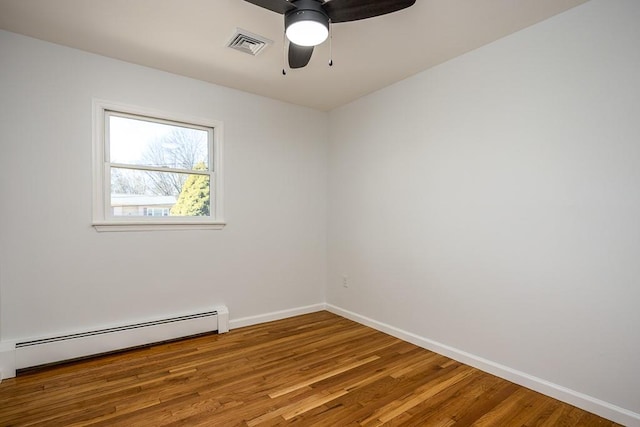 unfurnished room featuring visible vents, baseboards, wood finished floors, a ceiling fan, and a baseboard radiator