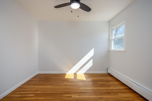 unfurnished room with a baseboard heating unit, wood finished floors, baseboards, and ceiling fan