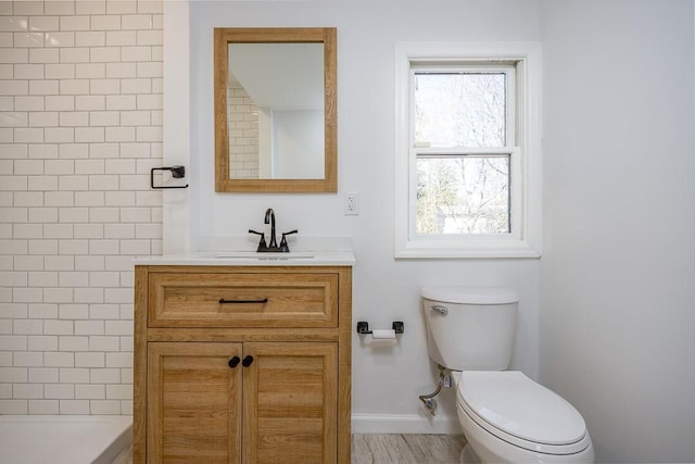 bathroom featuring vanity, toilet, and baseboards