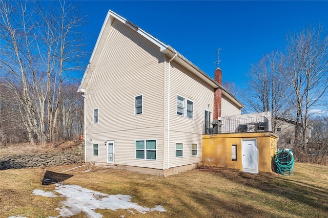 view of home's exterior with a lawn and a chimney